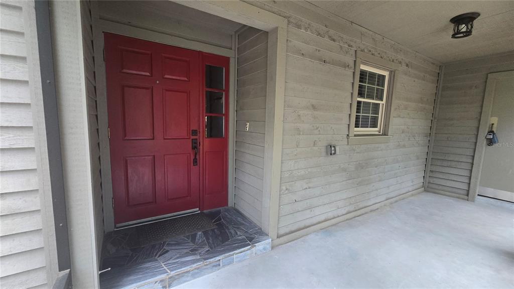 A view of a gray-sided house with a screened porch behind a wooden picket fence — 5201 SW 86 TERRACE, GAINESVILLE, FL