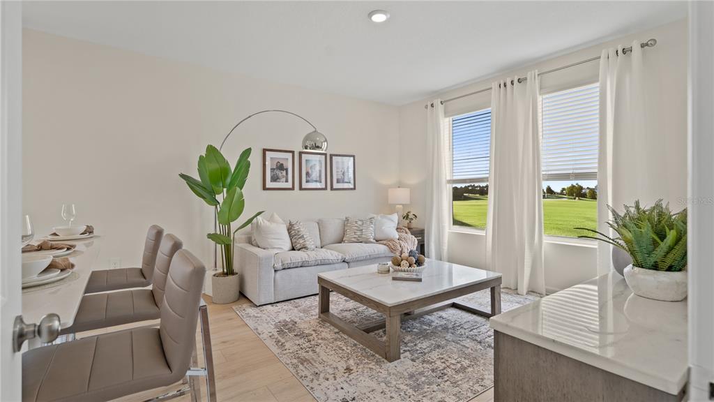 A living room features a sofa, marble coffee table, dining bar, and large windows — 171 GLENFIELD DRIVE, DAVENPORT, FL