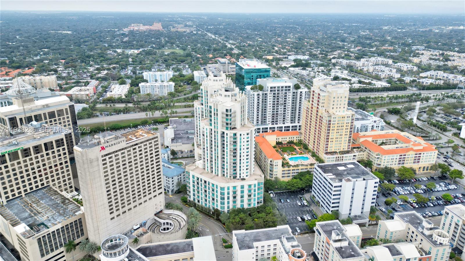 An aerial view shows several high-rise buildings, a Marriott hotel, and parking lots in a city — 9025 S DADELAND BLVD, Miami FL 33156, MIAMI, FL