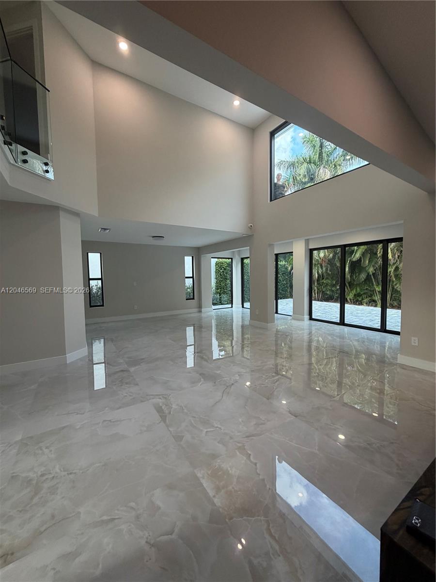 A spacious living area features high ceilings, large windows, and polished marble flooring — 4499 NW 93rd Doral Ct, Doral FL 33178, DORAL, FL