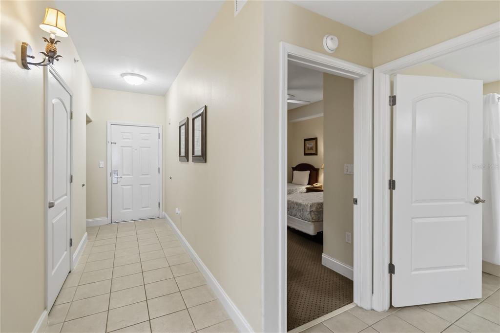 A tiled entryway leads to a front door, a bedroom doorway, and a closed door — 13427 BLUE HERON BEACH DRIVE UNIT 104, ORLANDO, FL