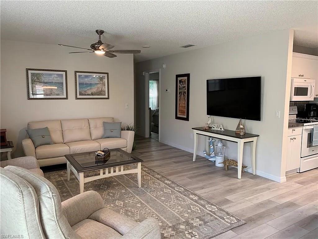 A dining area features a square wooden table with four chairs on a patterned rug — 1712 MORELOS ROAD, THE VILLAGES, FL