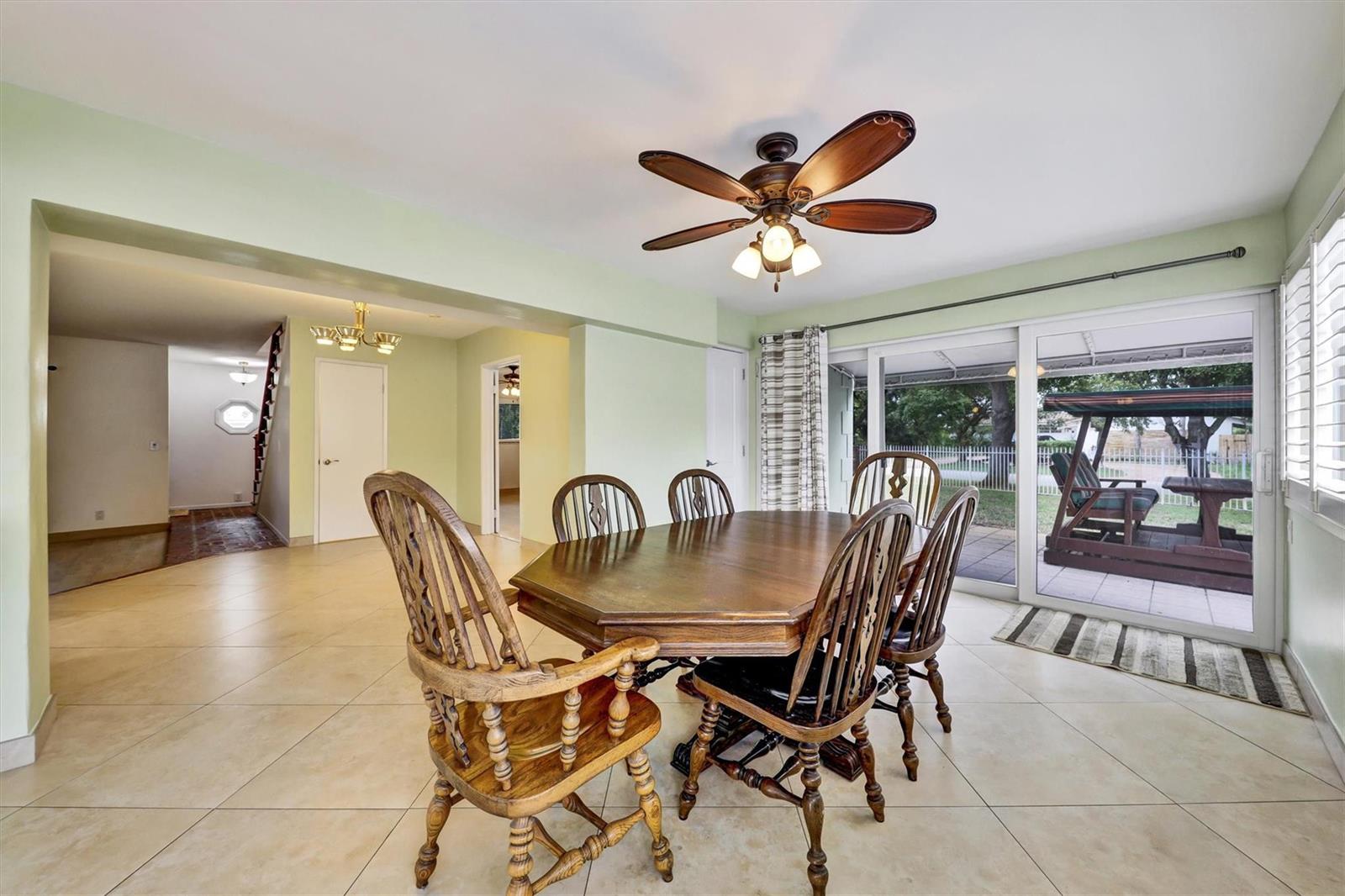 A dining room features a wooden table, spindle chairs, a ceiling fan, and sliding doors — 2780 SE 5th Court, Pompano Beach FL 33062, POMPANO BEACH, FL