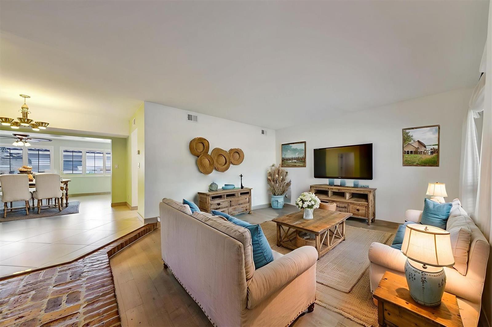 A living room with light wood floors, a beige sofa, and a wooden coffee table — 2780 SE 5th Court, Pompano Beach FL 33062, POMPANO BEACH, FL