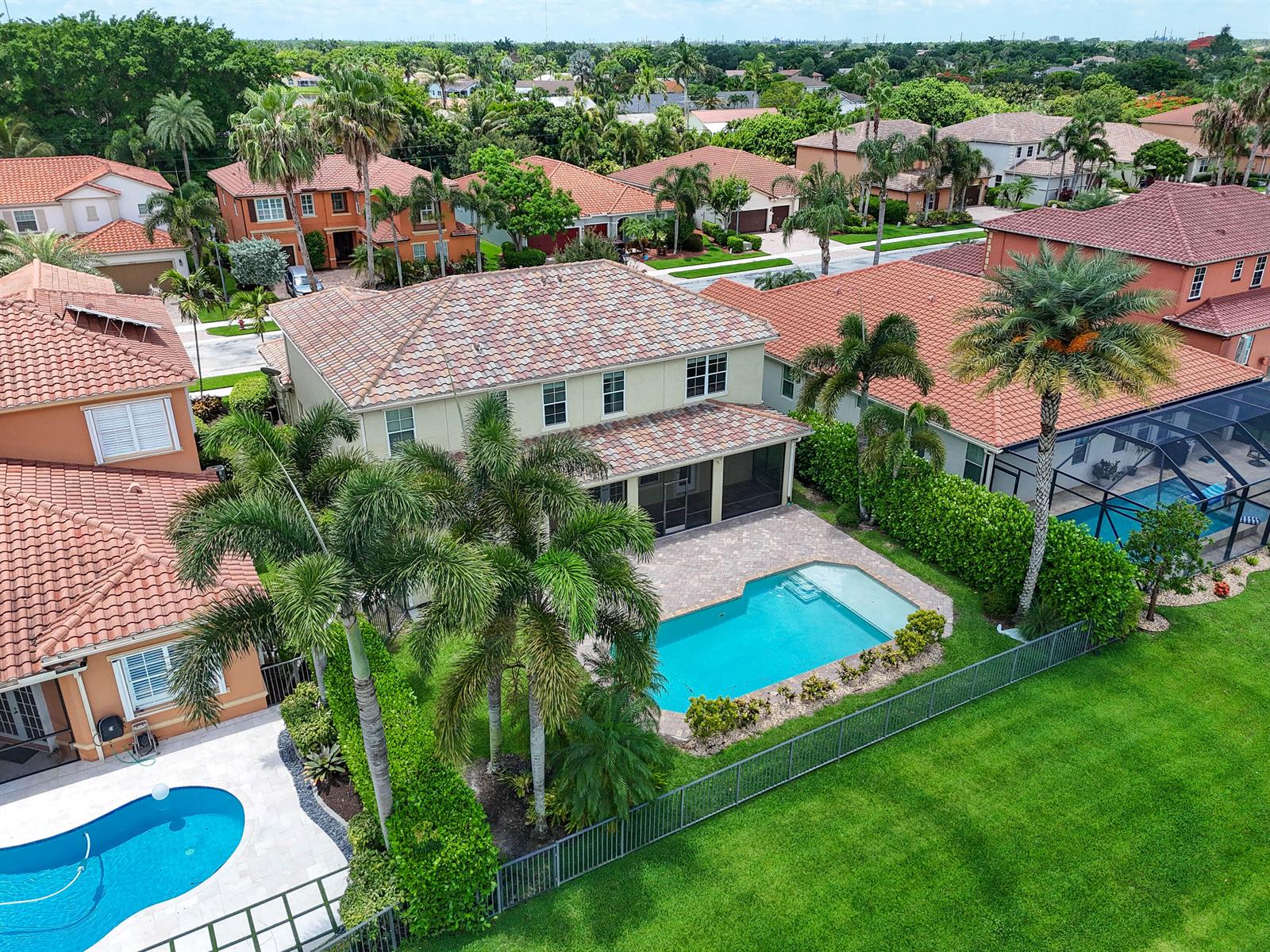An aerial view shows a two-story house with a tiled roof, pool, and backyard lawn — 10519 Longleaf Lane, Wellington FL 33414, WELLINGTON, FL