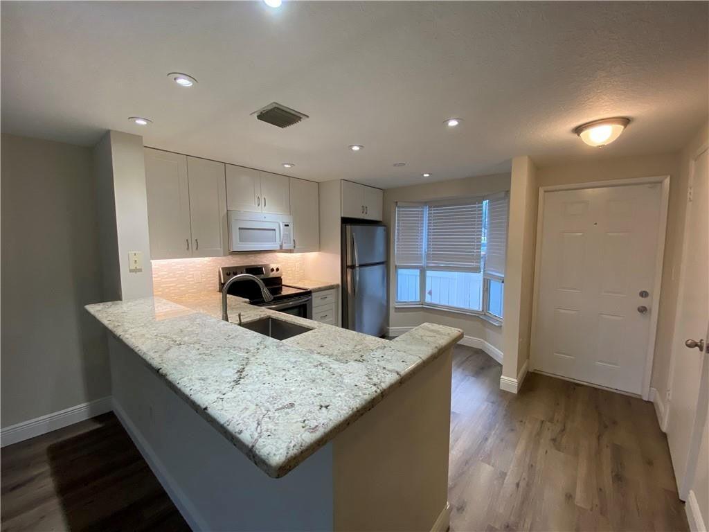 A kitchen with granite countertops, stainless steel appliances, and light-colored cabinetry — 1078 Jeffery Street, Boca Raton FL 33487, BOCA RATON, FL