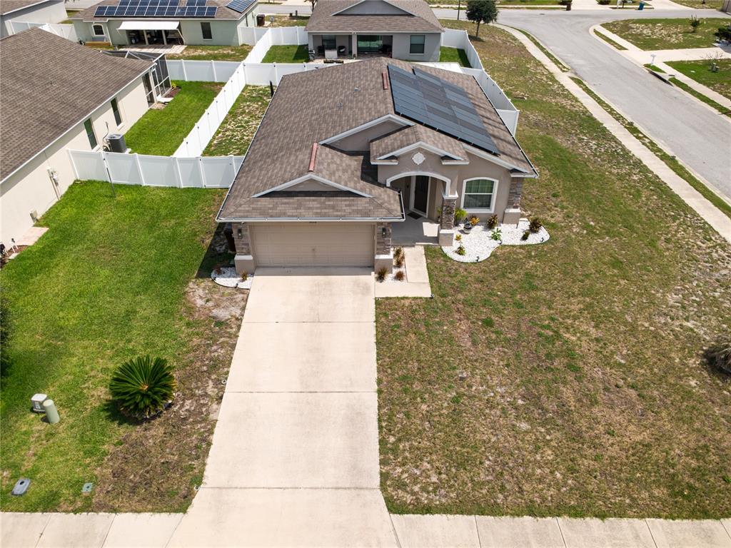 An aerial view of a single-story suburban house with a driveway and solar panels — 2628 SUNSET CIRCLE, LAKE WALES, FL
