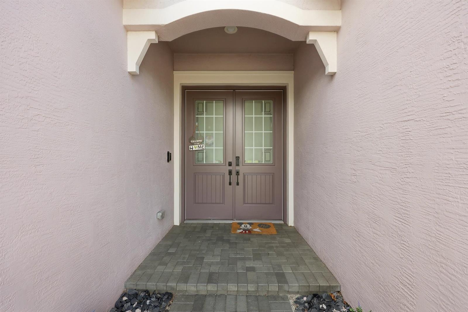 A front entryway features double doors with glass panels, a brick floor, and stucco walls — 15264 Wildwood Circle, Westlake FL 33470, WESTLAKE, FL