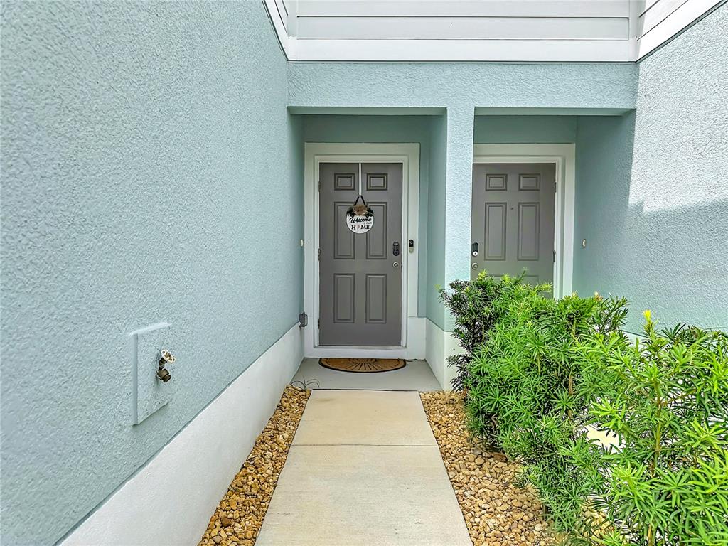 An exterior view of a home entrance with two gray doors and light blue siding — 14172 CRIMSON AVENUE, BRADENTON, FL