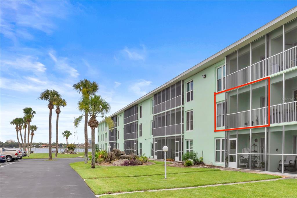 A multi-story apartment building with a screened-in balcony highlighted in red — 715 S BEACH STREET UNIT 211D, DAYTONA BEACH, FL