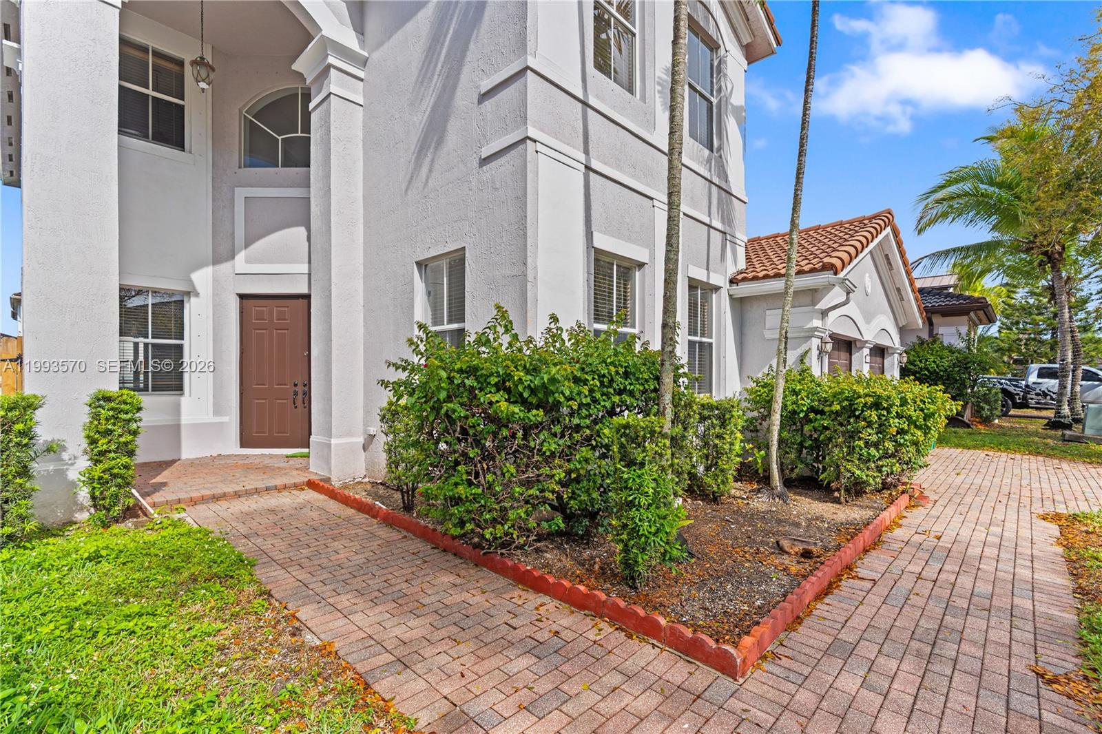 A two-story house with a brown front door, brick walkway, and landscaped front yard — 18140 NW 90th Ave, Hialeah FL 33018, HIALEAH, FL