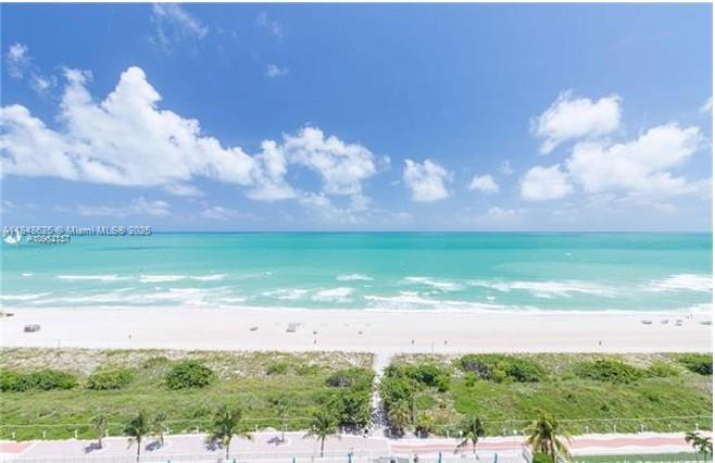 An elevated view of a sandy beach and turquoise ocean under a bright blue sky — 5701 Collins Ave # 1008, Miami Beach FL 33140, MIAMI BEACH, FL