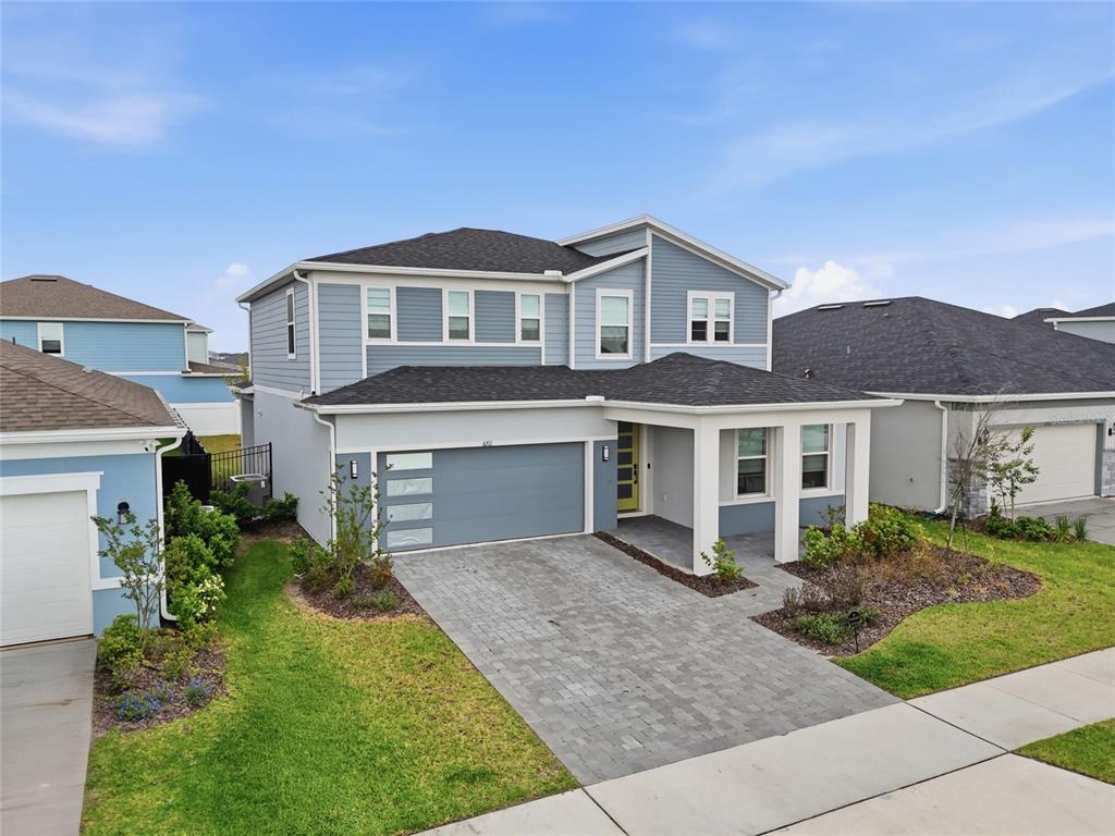 A two-story blue house with a gray garage and a paved driveway — 6711 WILLOW VIEW AVENUE, ORLANDO, FL