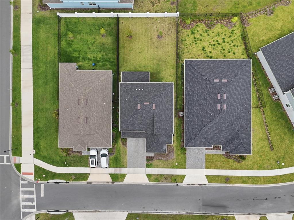 An aerial view shows three houses with driveways and backyards along a residential street — 6711 WILLOW VIEW AVENUE, ORLANDO, FL