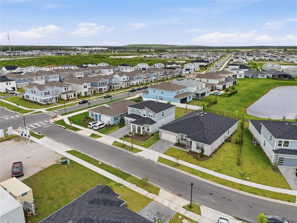 An aerial view shows a suburban neighborhood with multiple houses, paved streets, and a pond — 6711 WILLOW VIEW AVENUE, ORLANDO, FL