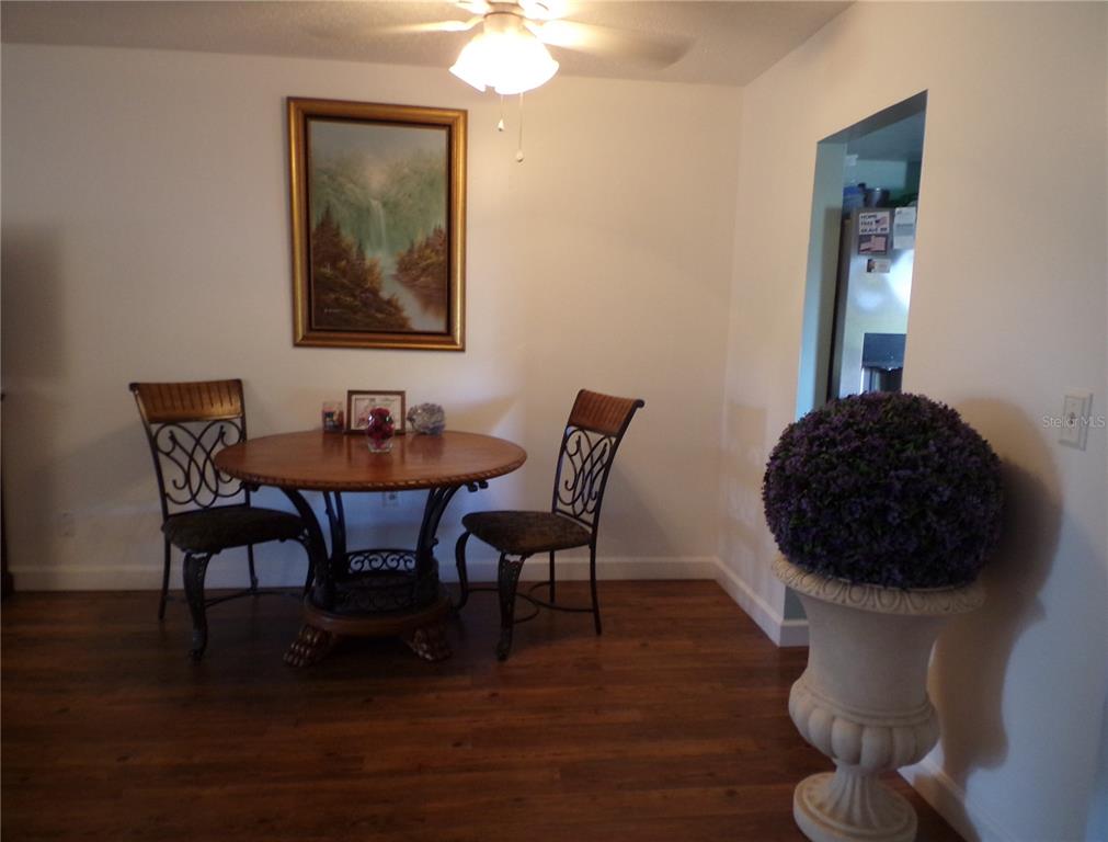 A dining area features a round wooden table, two chairs, and a decorative floor planter — 670 PARK CIRCLE, BRADENTON, FL