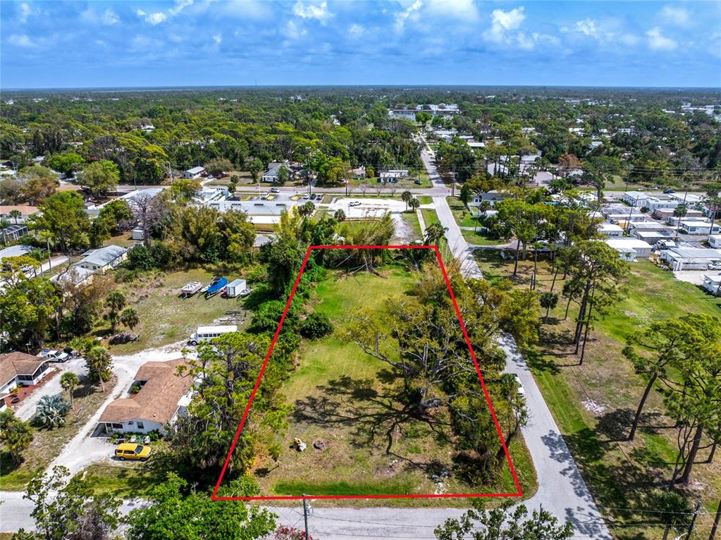 An aerial view shows a rectangular vacant lot outlined in red next to a road — PINEAPPLE STREET, ENGLEWOOD, FL