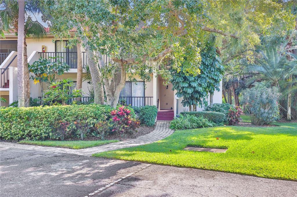 A two-story apartment building with a brick walkway leading to a ground-level entrance — 3450 WOOD OWL CIRCLE UNIT 284, BRADENTON, FL