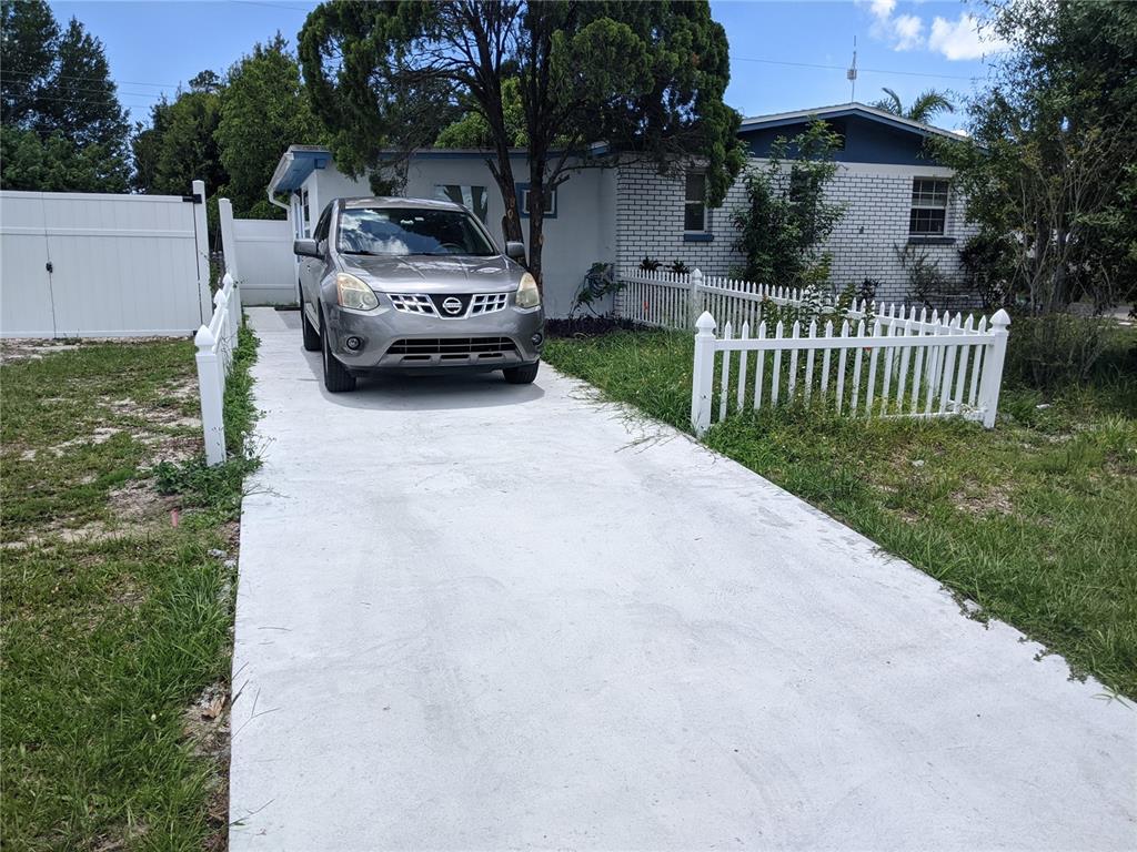 A silver SUV is parked on a concrete driveway in front of a white house — 4538 W MINNEHAHA STREET UNIT B, TAMPA, FL