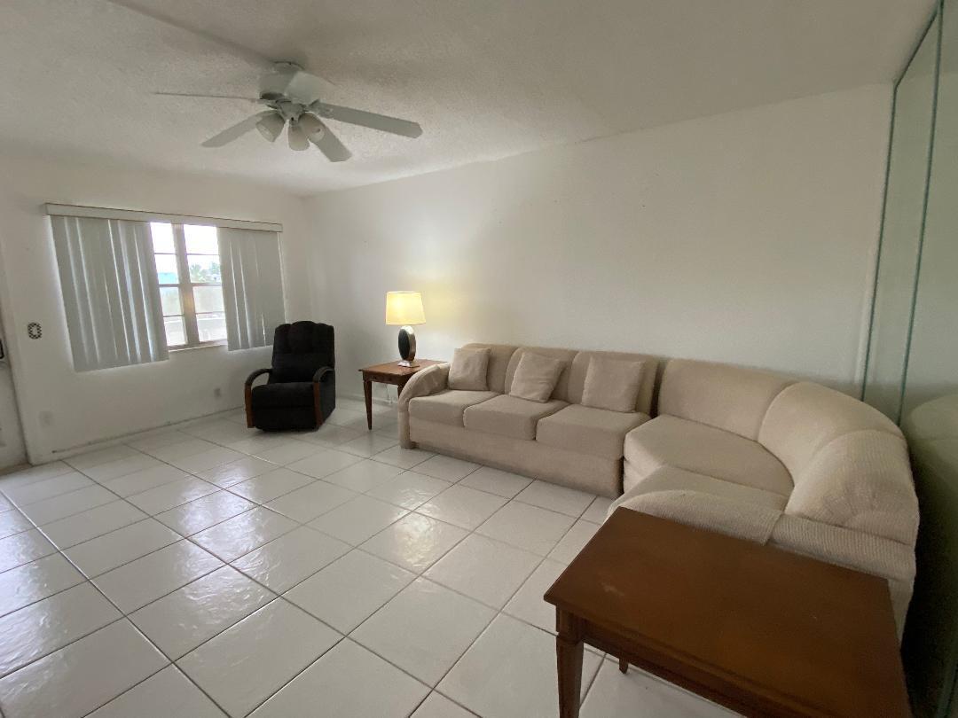 A living room with white tile floors, a beige sectional sofa, and a ceiling fan — 3043 Berkshire C, Deerfield Beach FL 33442, DEERFIELD BEACH, FL