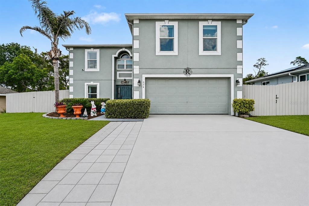 A two-story house with a gray exterior, white trim, and a two-car garage — 614 N FIRWOOD DRIVE, DELTONA, FL