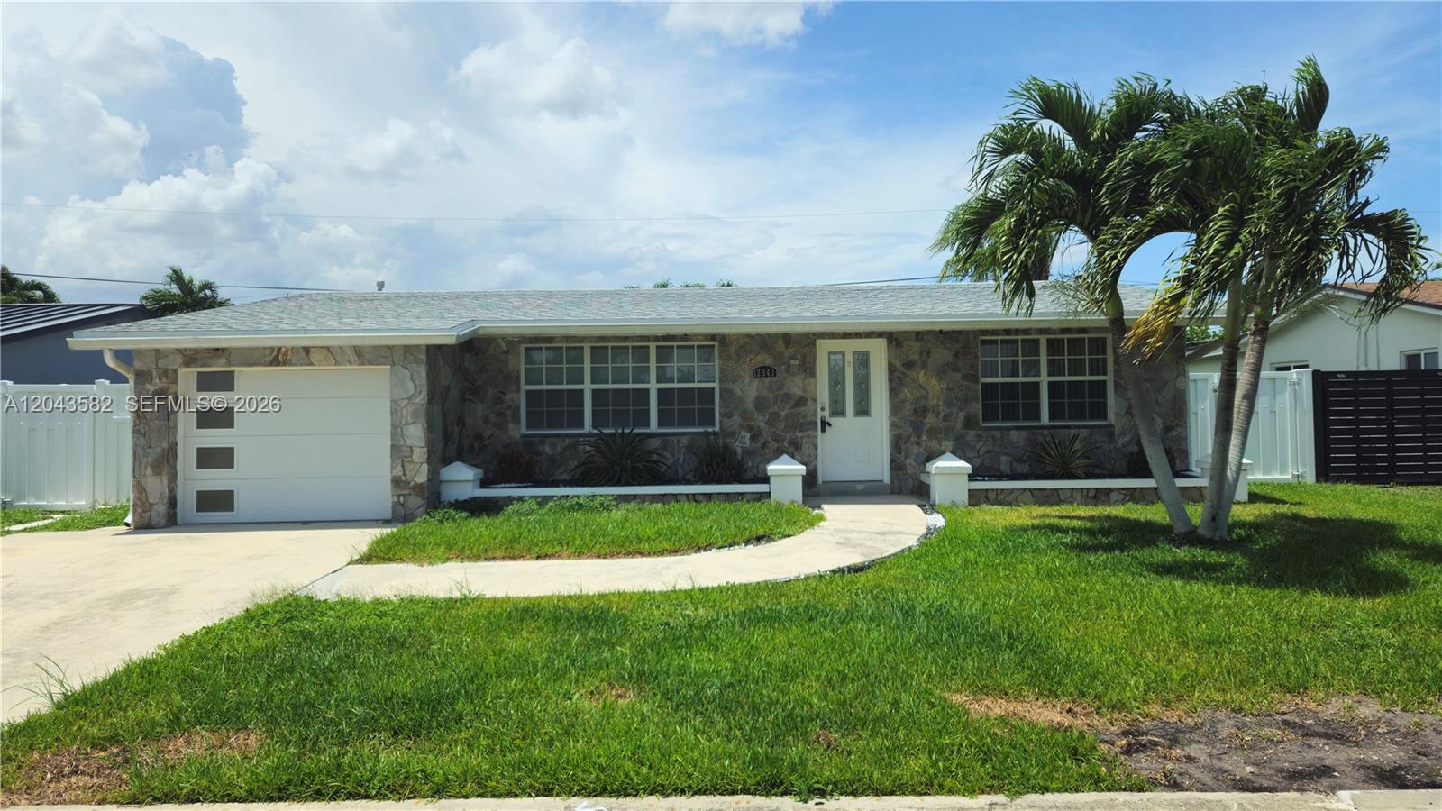 A single-story house with a stone facade, a white garage door, and a palm tree — 12341 NW 30th St, Sunrise FL 33323, SUNRISE, FL