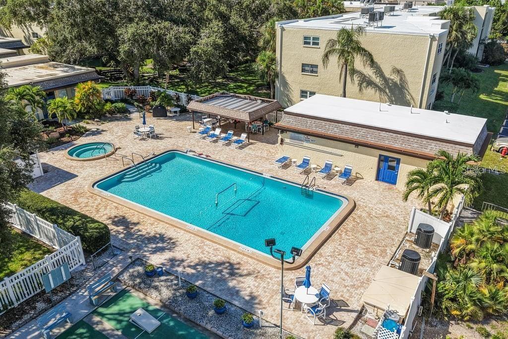 An aerial view of a swimming pool, hot tub, and covered patio area at a complex — 11485 OAKHURST ROAD UNIT 200-208, LARGO, FL
