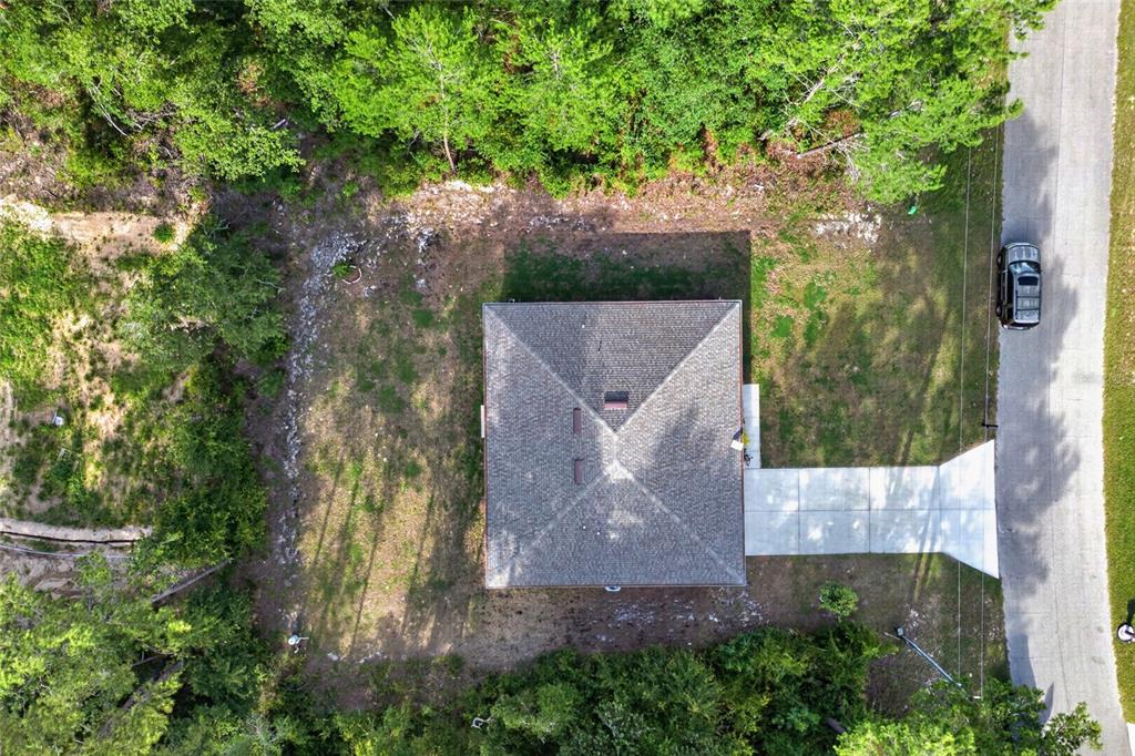 An aerial view shows a house with a hip roof, a concrete driveway, and surrounding trees — 8257 SW 129TH PLACE, OCALA, FL