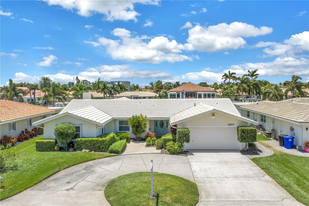 A single-story house with a white roof, light-colored siding, and a circular driveway — 2067 MASSACHUSETTS AVENUE NE, ST PETERSBURG, FL
