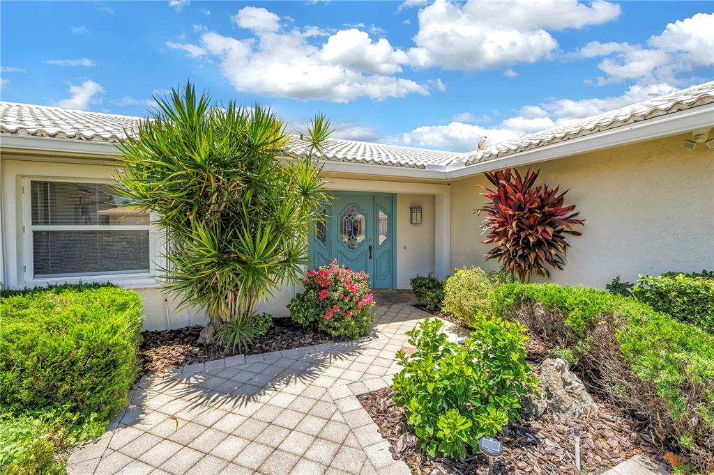 A paved walkway leads to the light blue front door of a single-story house — 2067 MASSACHUSETTS AVENUE NE, ST PETERSBURG, FL