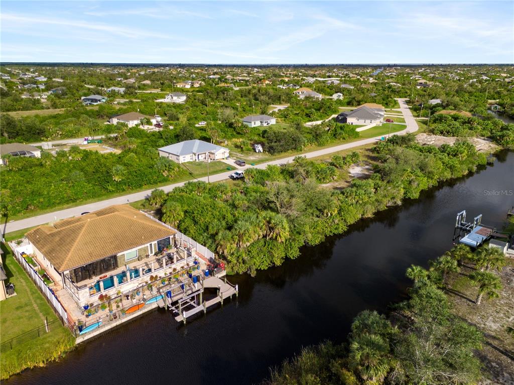An aerial view shows a waterfront house with a dock and pool along a canal — 13886 ALLAMANDA CIRCLE, PORT CHARLOTTE, FL