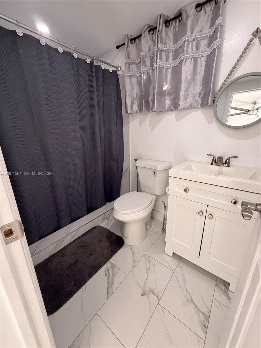 A bathroom features a white vanity, a toilet, and a dark shower curtain — 1037 SW 20th Ave # 2, Miami FL 33135, MIAMI, FL