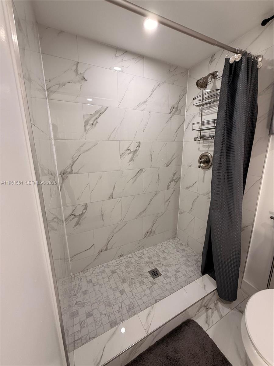 A walk-in shower features white marble-look wall tiles and a mosaic tile floor — 1037 SW 20th Ave # 2, Miami FL 33135, MIAMI, FL