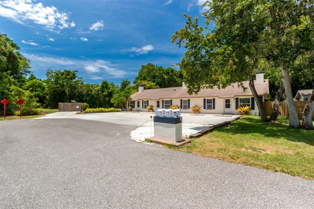 A single-story multi-unit building with a concrete parking lot and a central mailbox station — 355 23RD AVENUE SW, SEMINOLE, FL