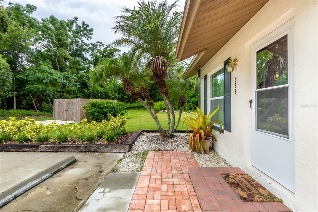A brick walkway leads to the front door of a house with a palm tree — 355 23RD AVENUE SW, SEMINOLE, FL