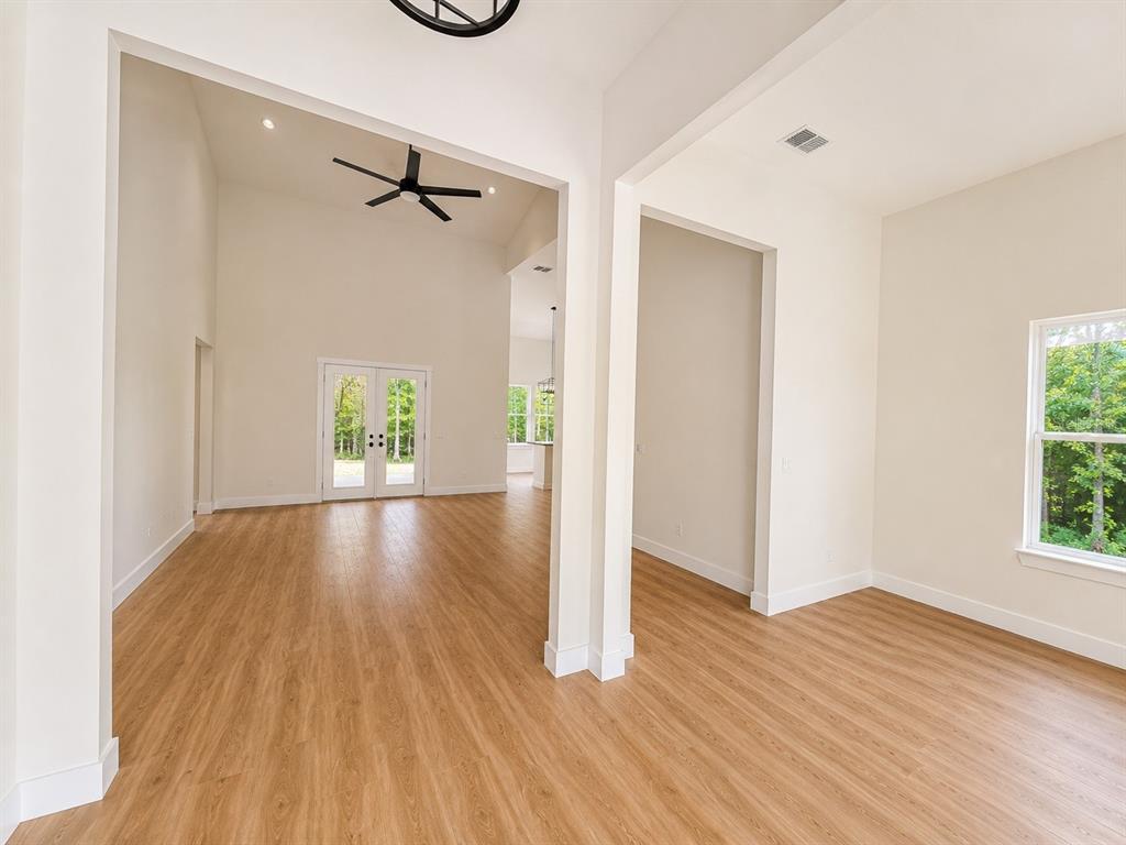 An interior view shows an open-concept living area with light wood flooring and high ceilings — 490 RIVERWOODS TRAIL, CHULUOTA, FL