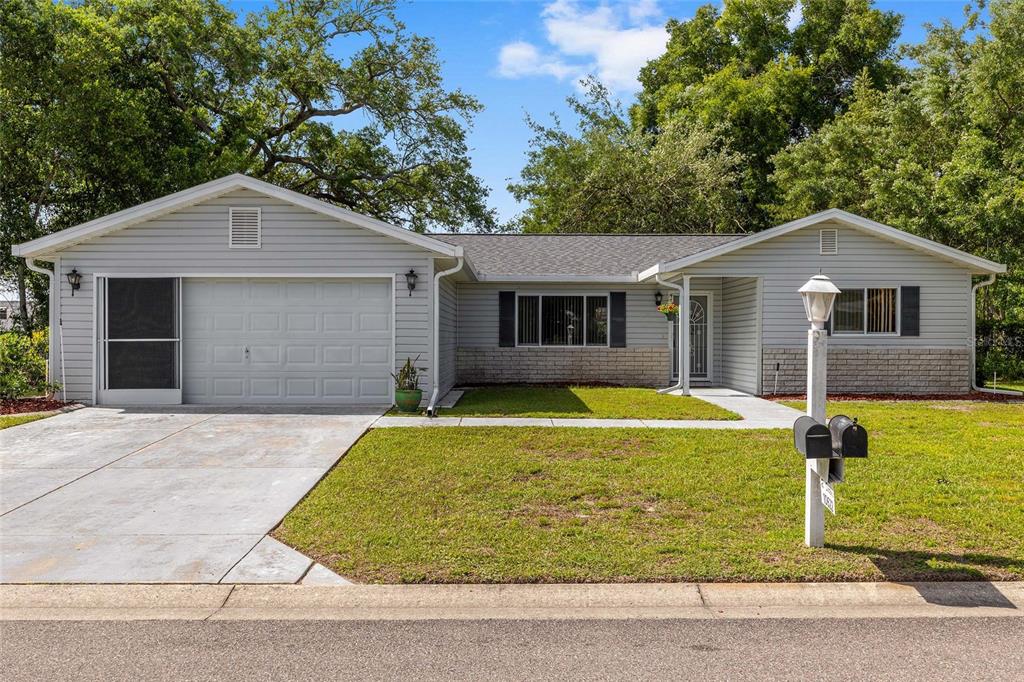 A single-story house with light gray siding, a two-car garage, and a front lawn — 10622 SE 179TH LANE, SUMMERFIELD, FL
