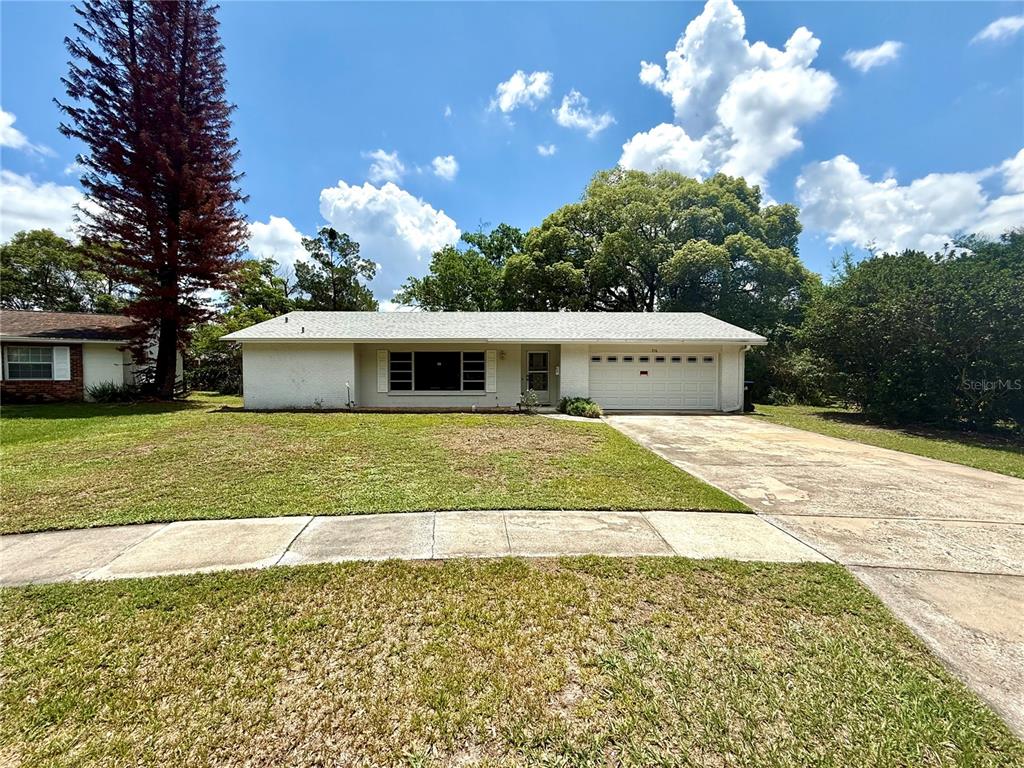 A single-story white house with a two-car garage and a large front lawn — 316 BECKETT COURT, WINTER PARK, FL