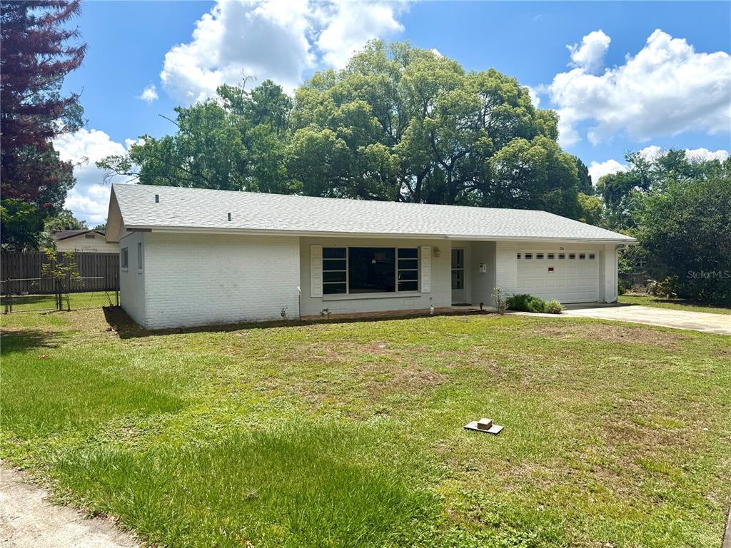 A single-story white brick house with a garage and a large front yard — 316 BECKETT COURT, WINTER PARK, FL
