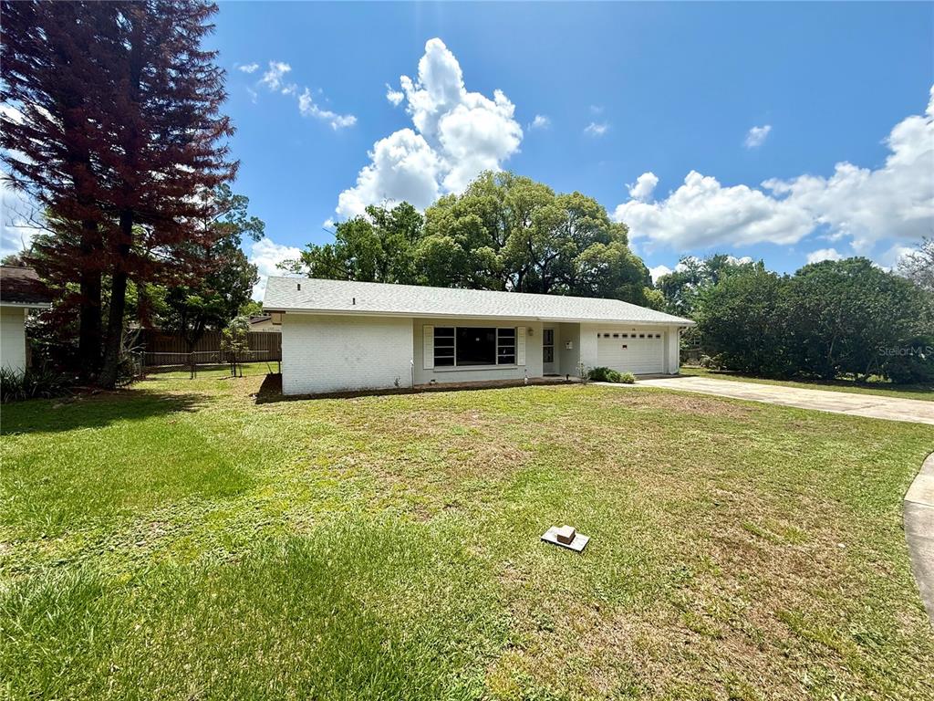 A single-story white brick house with a garage and a large front lawn — 316 BECKETT COURT, WINTER PARK, FL