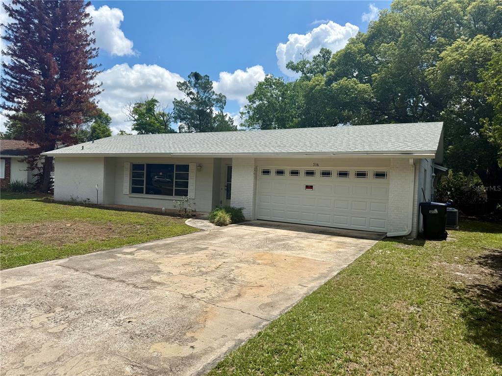 A single-story white brick house with a gray shingled roof and a concrete driveway — 316 BECKETT COURT, WINTER PARK, FL