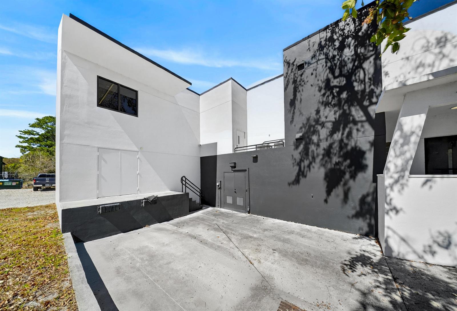The exterior of a modern building features a concrete loading dock and gray double doors — 405 Angle Road, Fort Pierce FL 34947, FORT PIERCE, FL