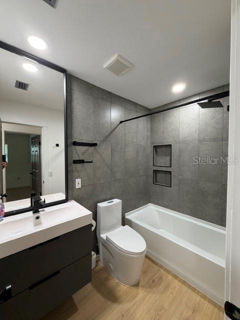 A modern bathroom features a floating vanity, a toilet, and a tiled tub-shower combination — 1407 PARK LAKE STREET, ORLANDO, FL