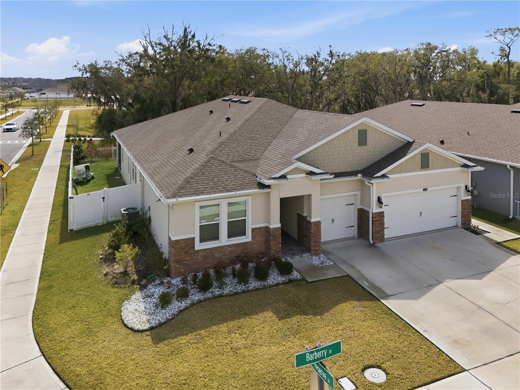 An aerial view of a single-story suburban house with a two-car garage and landscaping — 1636 BARBERRY DRIVE, KISSIMMEE, FL
