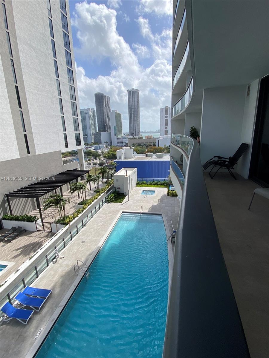 A high-angle view shows a balcony overlooking a swimming pool and city skyline — 1600 NE 1st Ave # 1117, Miami FL 33132, MIAMI, FL
