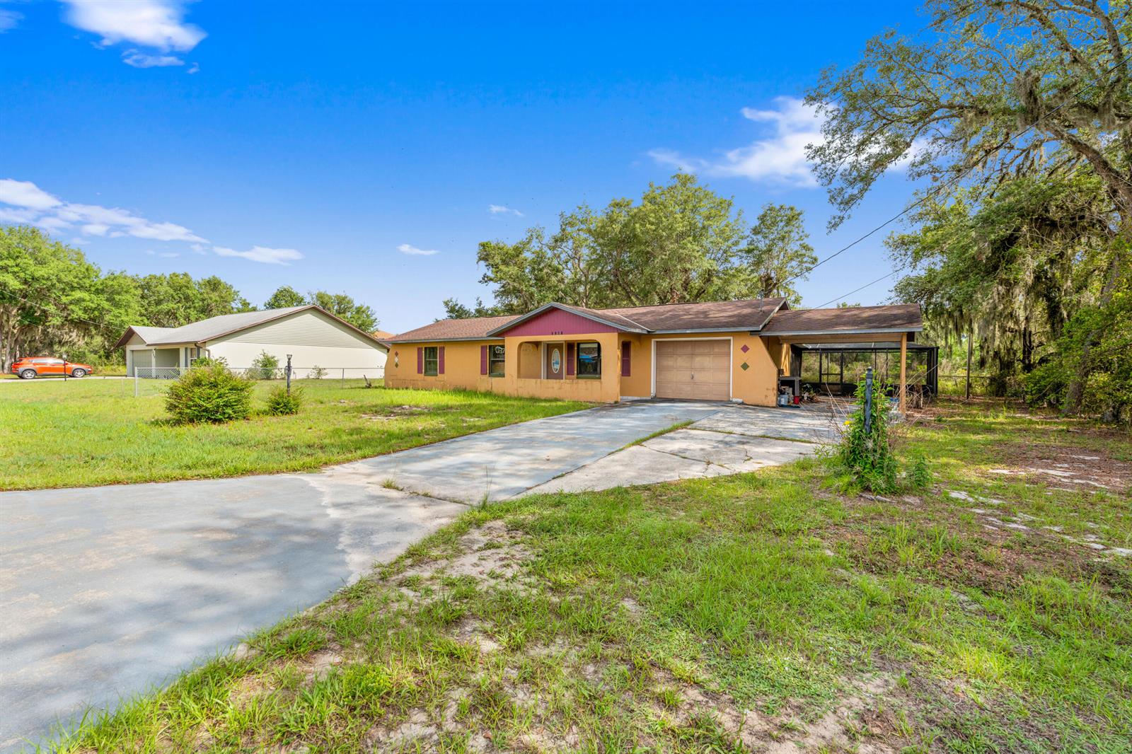A single-story house with a tan exterior, a front porch, and an attached carport — 2907 N Lancaster Road, FL 33825, FL