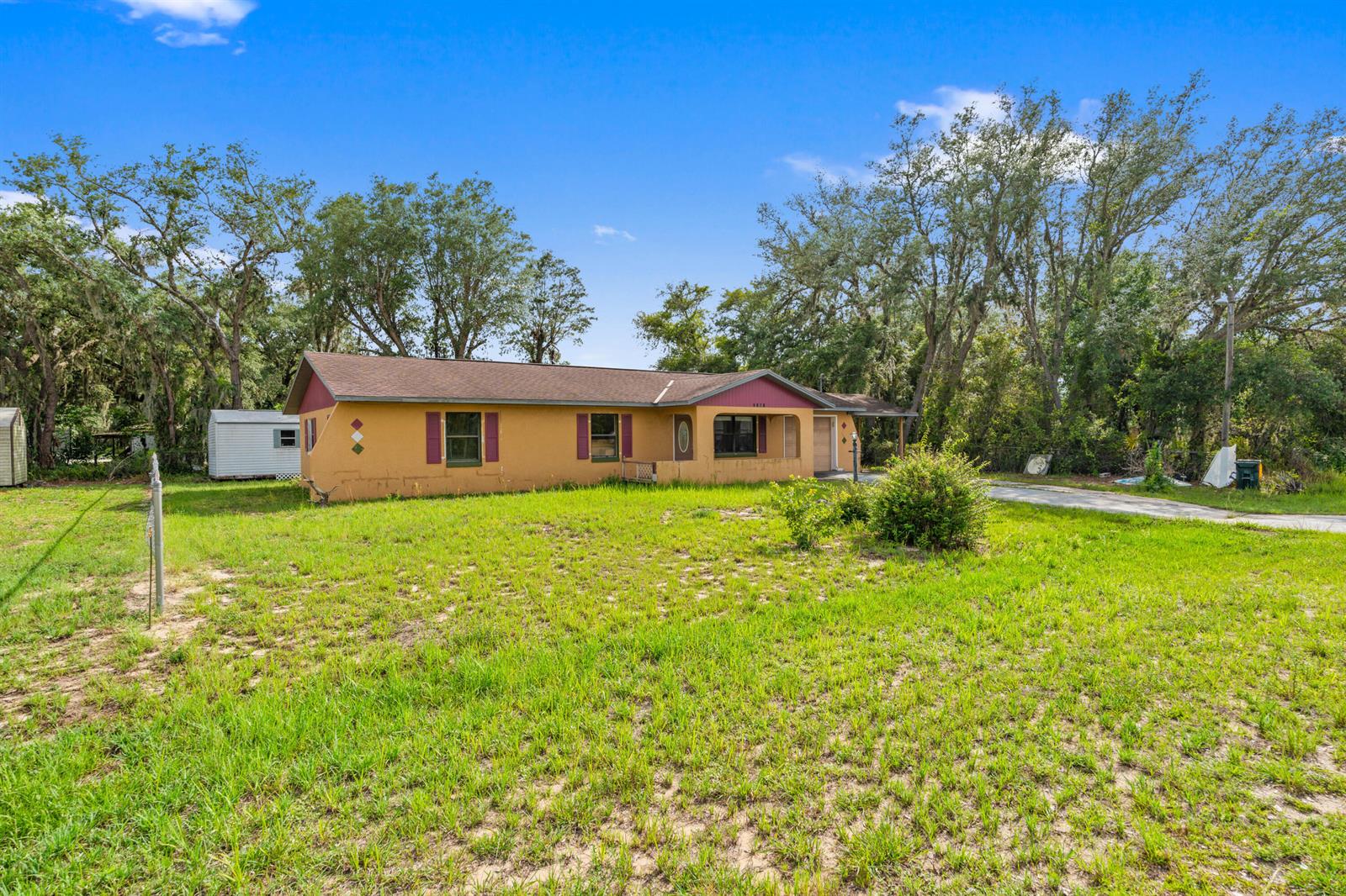 A single-story yellow house with a brown roof sits on a grassy lot — 2907 N Lancaster Road, FL 33825, FL