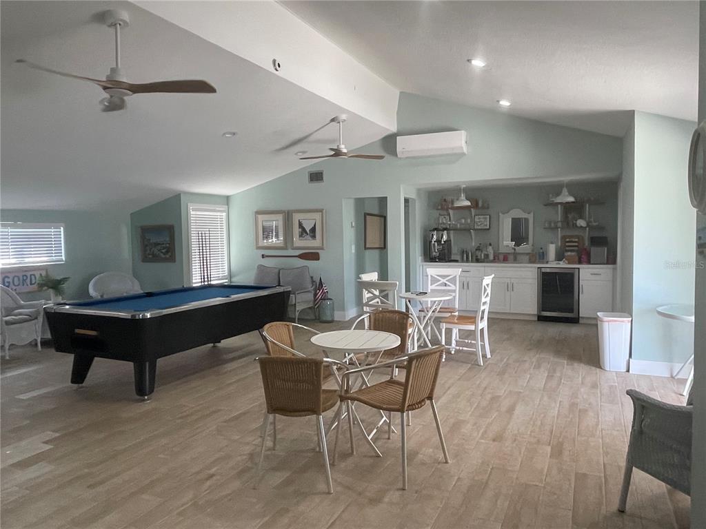 A spacious room features a pool table, a small bar area, and tile flooring — 1001 W MARION AVENUE UNIT 8, PUNTA GORDA, FL