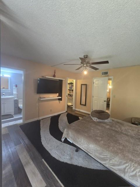 A bedroom features a bed, a wall-mounted television, a ceiling fan, and an attached bathroom — 5160 Las Verdes Circle # 217, Delray Beach FL 33484, DELRAY BEACH, FL
