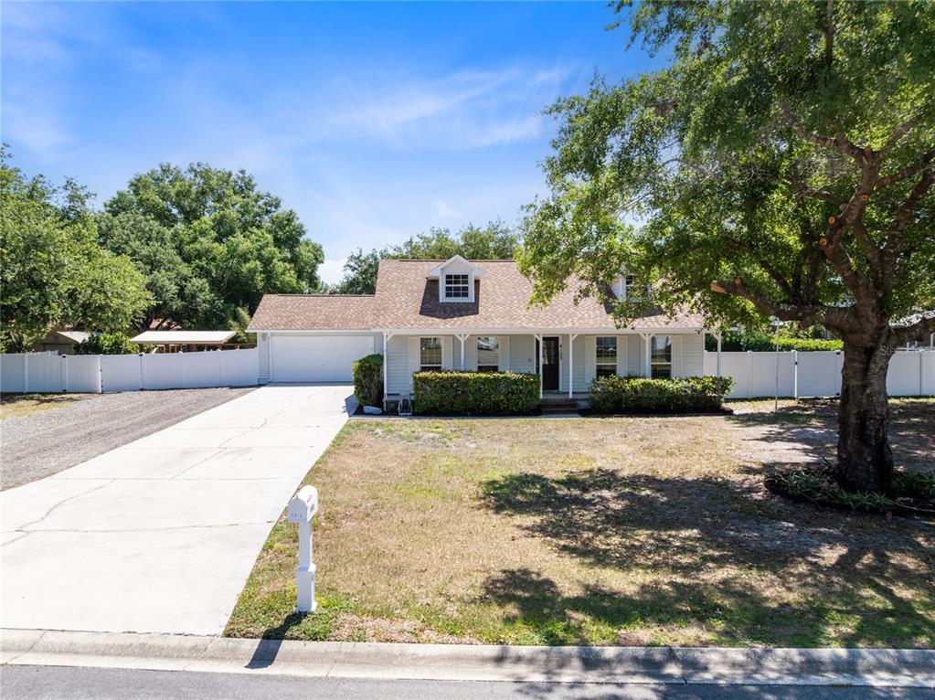 A single-story house with a white exterior, a two-car garage, and a large front yard — 4103 BOB WHITE COURT, ST CLOUD, FL